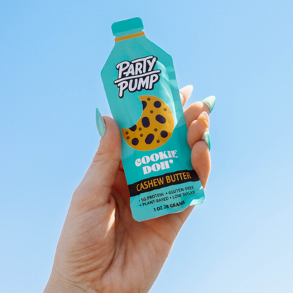 Party Pump Cookie Doh' Squeezie – hand holding a cookie dough Squeezie against a clear blue sky